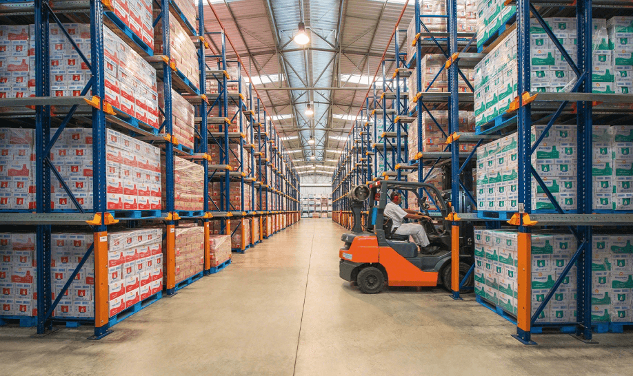Drive-in pallet racking system in a warehouse — high-density LIFO storage with forklift-accessible lanes and rail guides